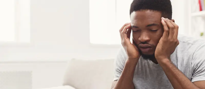 Male with his head in his hands dealing with trauma