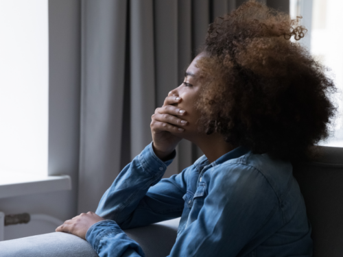 Woman sitting with hand on face dealing with emotional abuse