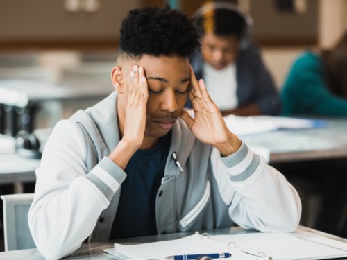 Student with hand on head dealing with stress from schoolwork