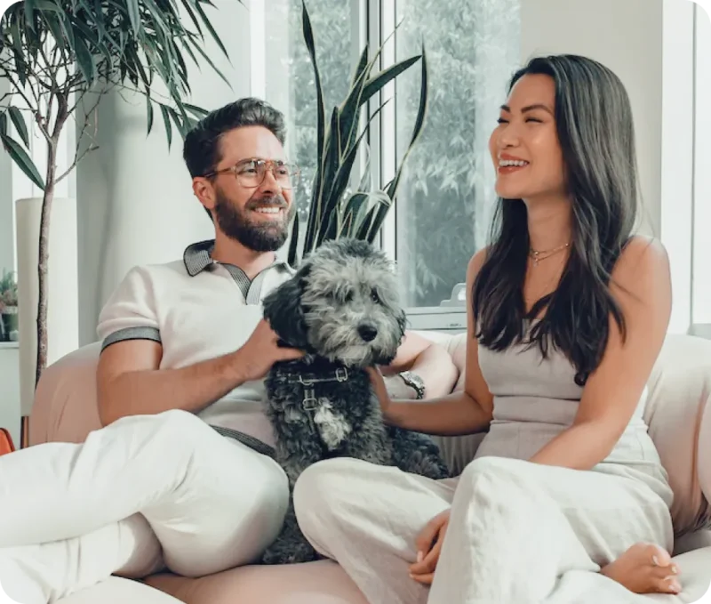 Man and woman chumming it up with lovely labradoodle