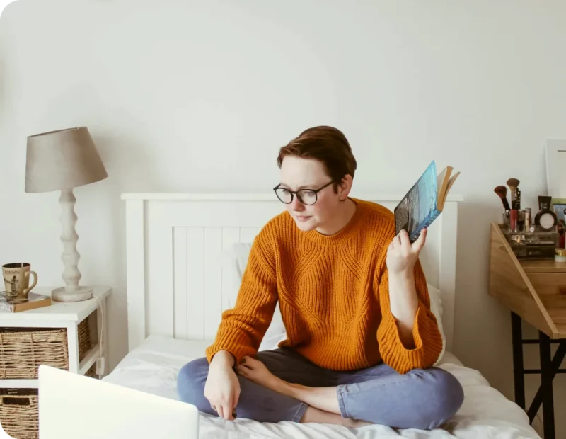 Girl on bed looking at laptop