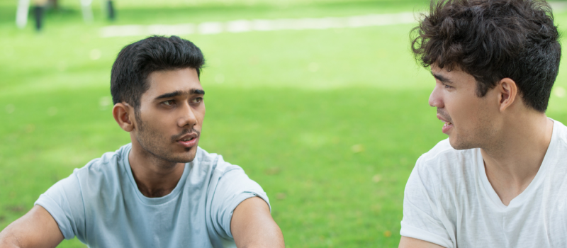 Two teens chatting in a park talking about how they are feeling anxious