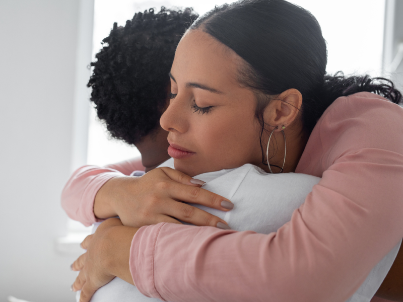 Parent giving their teen a hug to comfort them