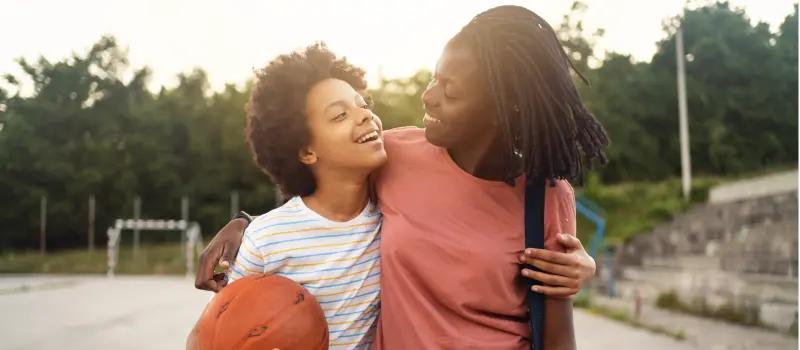 Two people in a friend relationship hug walking off a basketball court