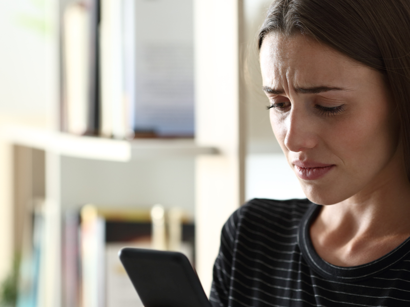 Teen girl experiencing trauma looking at her phone