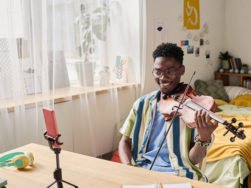Male teenager playing his violin for music therapy