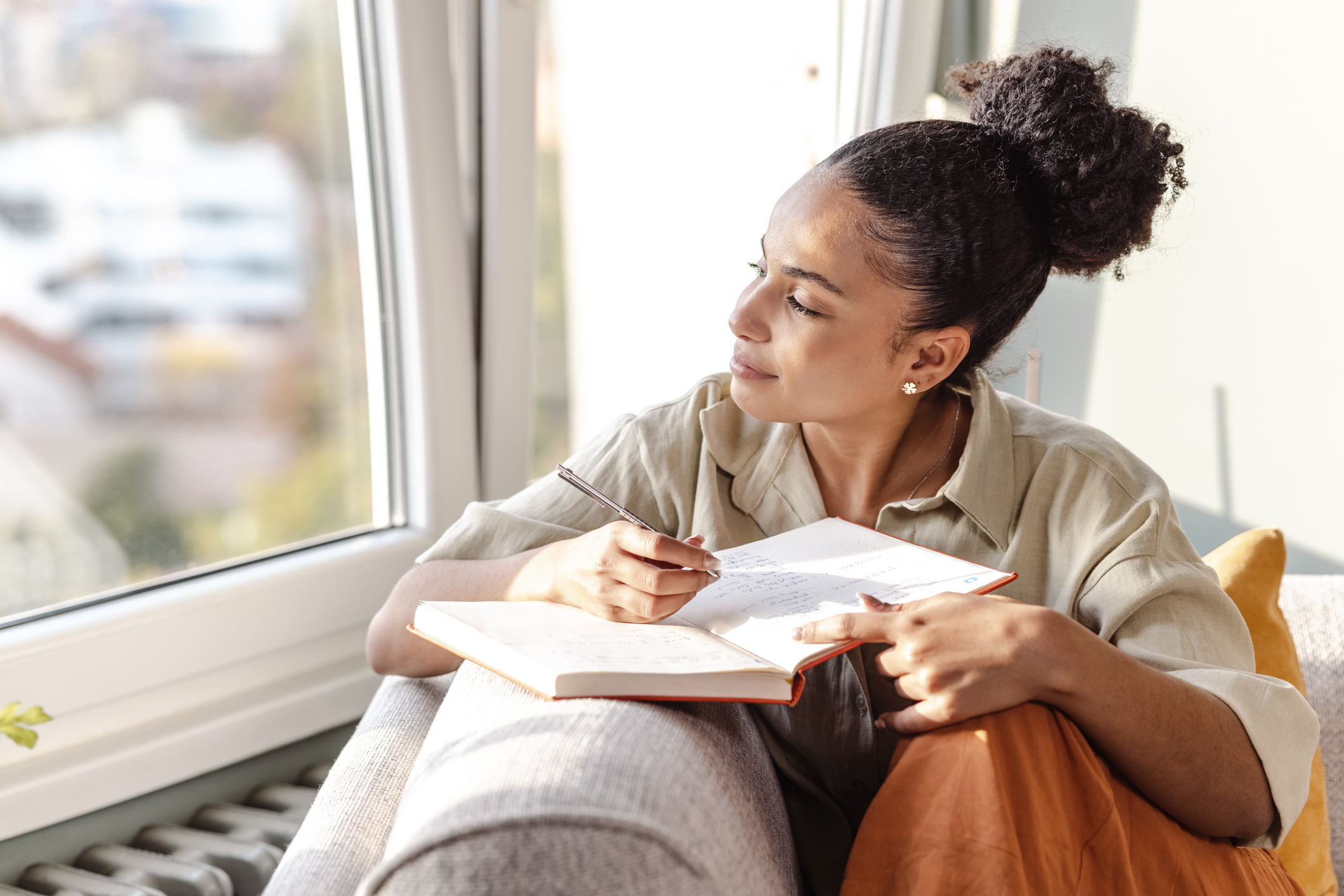 Woman setting goals in her journal knowing that completing them will have a positive impact on her mental health