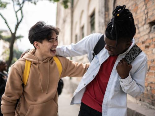 Two people walk side-by-side laughing. They are able to live happily while managing bipolar disorder.