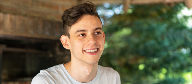 A young person smiles after watching a video on TikTok about beige flags.