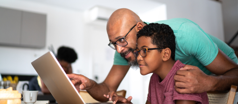 A parent and child wearing glasses look at a screen during a virtual teen family therapy session.