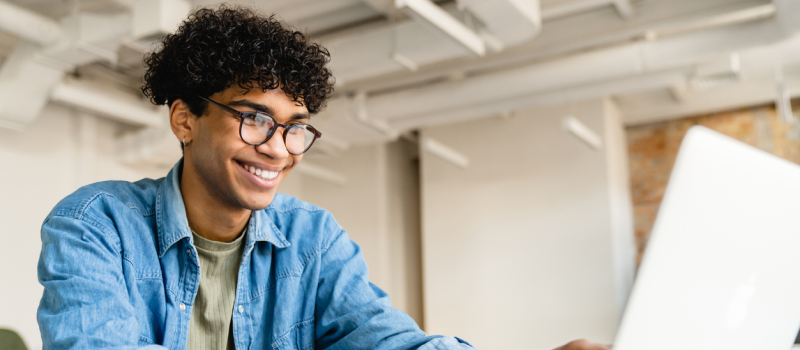 Male teenager in a denim jacket, green shirt, and glasses. He has recently completed IOP for his mental health.