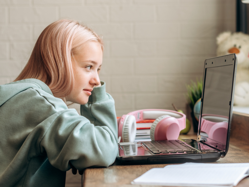 Young female in green sweatshirt at her desk. She is in therapy to manage depression.