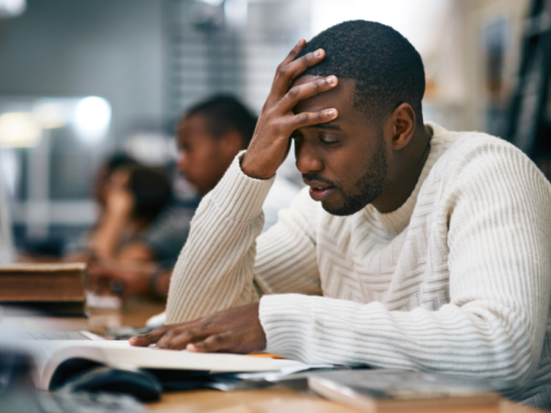 A person struggling with phobias reads about counterconditioning in a textbook while wearing a white sweater.