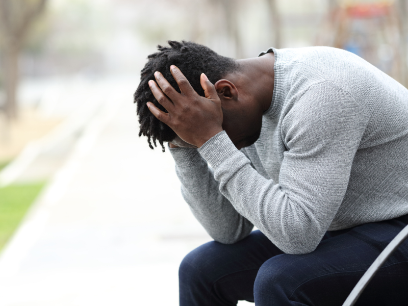 Young male in a grey sweatshirt and dark pants outside. He is currently being treated for depression.