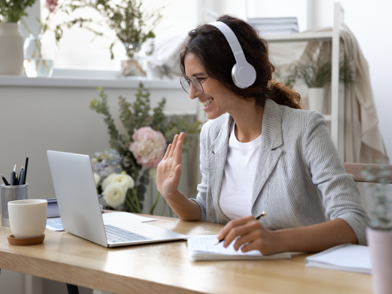 Young female in a striped blazer with a white shirt and headphones on. She is virtual dialectical behavior therapy (DBT).
