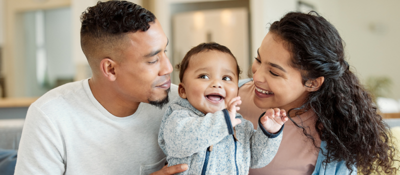 Young parents with their infant child. They are navigating how to support their mental health as a new parent.