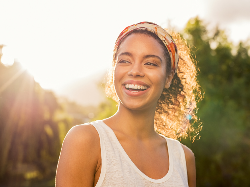 A young female in a white shirt wearing a colorful headband. She has been single for a long time and has encountered some psychological effects from it.