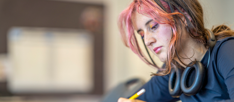 Young female with pink and brown hair. She is creating a self-harm safety plan.
