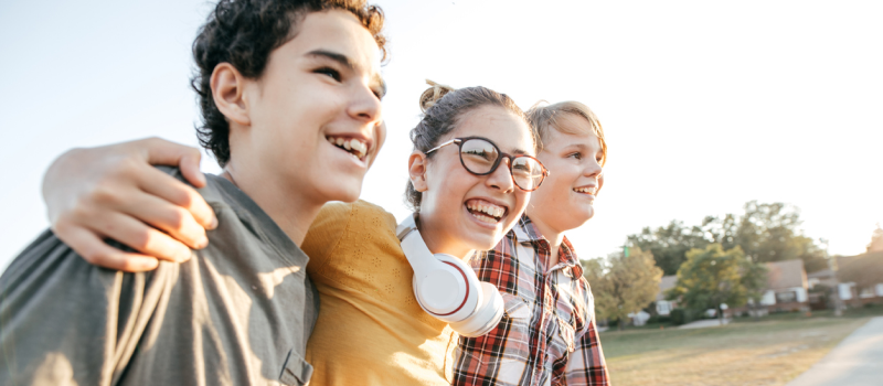 Three young teens walk outside of school together. They are learning about the depression and neurodivergence. 