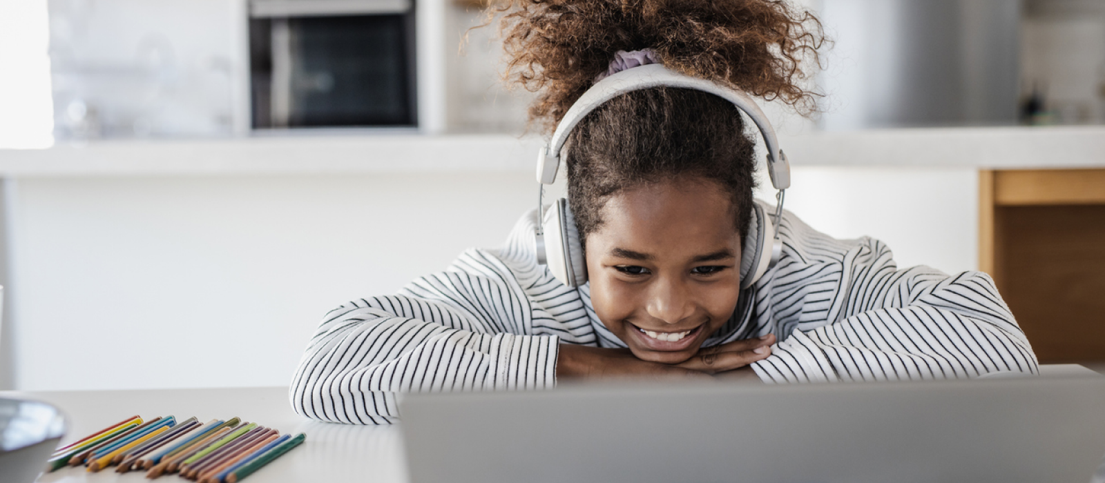 A young teenager sits at home on her computer. She is in Charlie Health's virtual IOP, whose mission is to connect the world to life-saving mental health treatment.