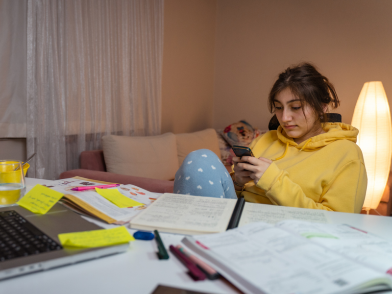 A young female sits at her desk. She is having a manic episode and is using tips to cope.