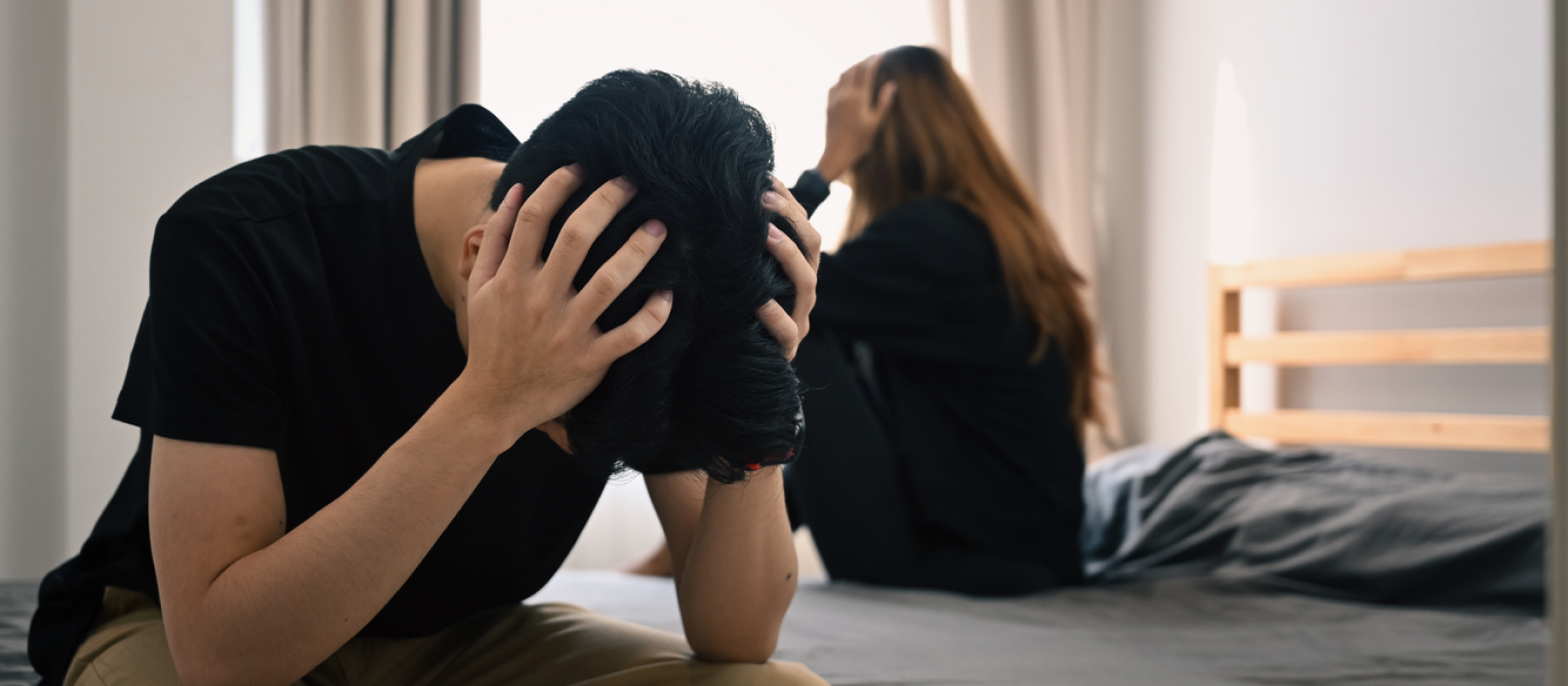 A young boy and girl sit on a bed after arguing. They need to use their coping skills when experiencing stonewalling for their relationship.