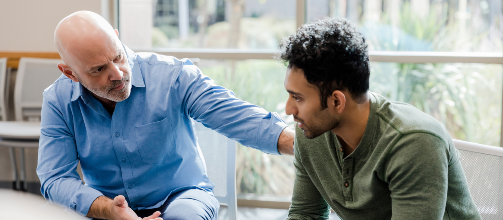 A young man sits with his father. He is leaning on his support system to stop hyperfixating on a person.