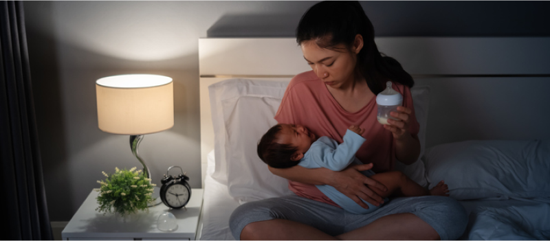 Mom with PPD holding her infant in bed