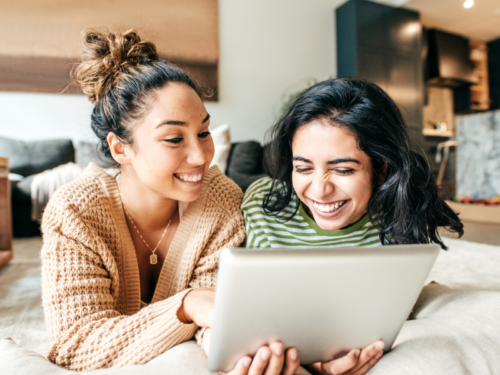 Two friends sit on their beds laughing. They want to set New Year's resolutions that therapists actually recommend.