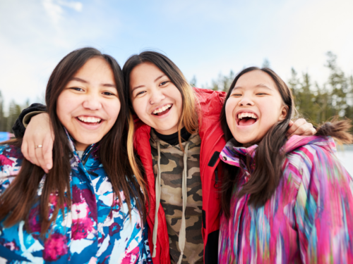 The three siblings hug. One of them is a middle child that knows the phrase