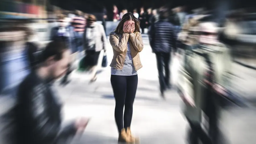 Girl in public frightened because she is experiencing paranoid delusions