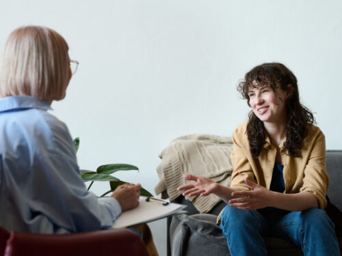 A woman sits for a therapy session with a female therapist who she chose to receive gender-affirming care.