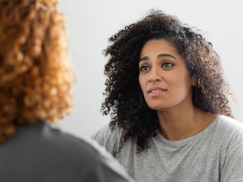 A person with schizophrenia sits in group therapy talking with another group member.