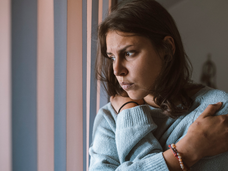 A woman in a blue sweater considers how to use DBT to manage depression.