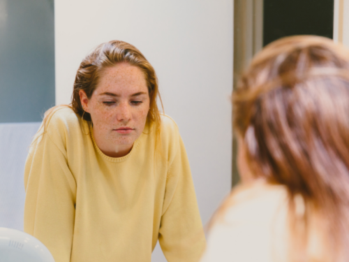 A young woman looks in the mirror as she uses a DBT skill to help manage her BPD.