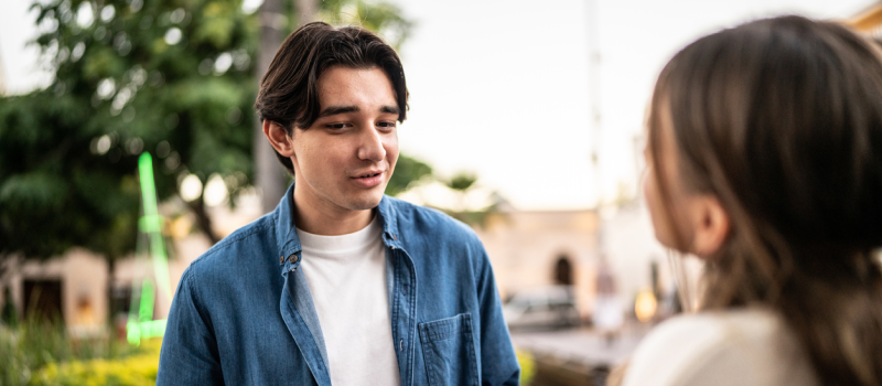 A boy in a blue shirt talks with a narcissistic person who he is trying to learn how to set boundaries with.