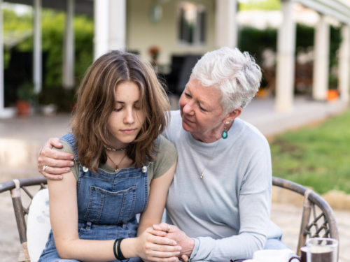 A young woman is in CBT for anxiety, her grandmother is giving her a hug.