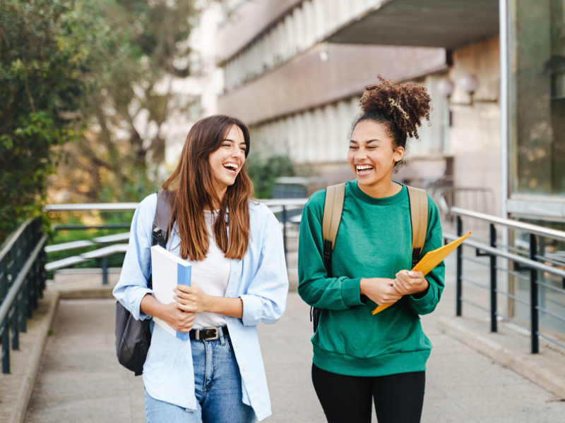 A college student laughs with her friend after using CBT for anger management.