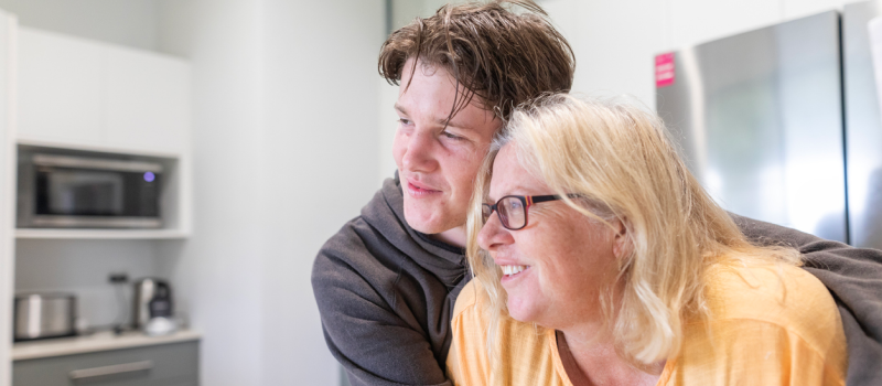 A young man hugs his mom after receiving treatment for developmental trauma disorder.