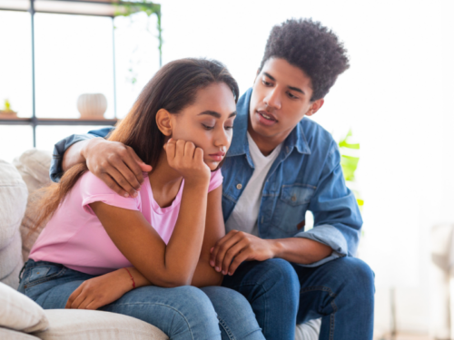 A young woman is being comforted by her partner because she feels like a failure, which may signal a mental health condition.