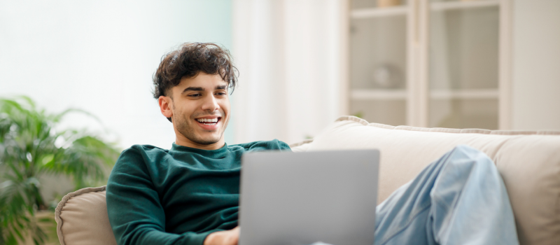 A young man looks into OCD treatment and medication management at Charlie Health on his computer.