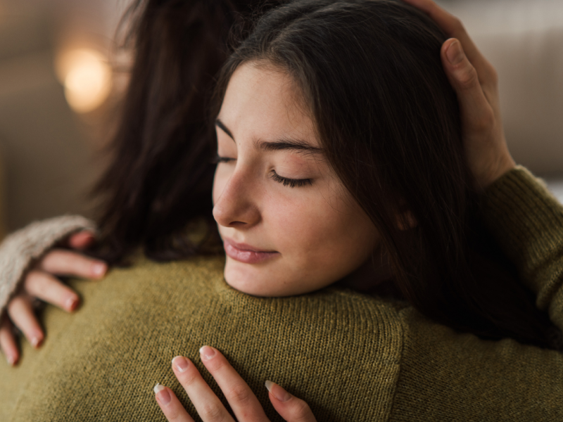 A woman hugs her daughter after a mental health crisis.