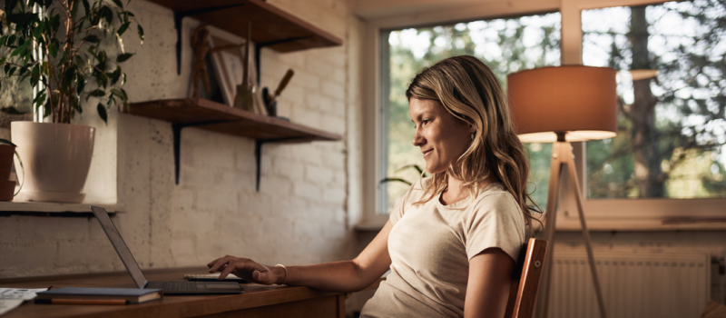 A young woman sits at home on a virtual computer call.