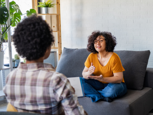 A woman sits in her therapists office in a DBT session for addiction.