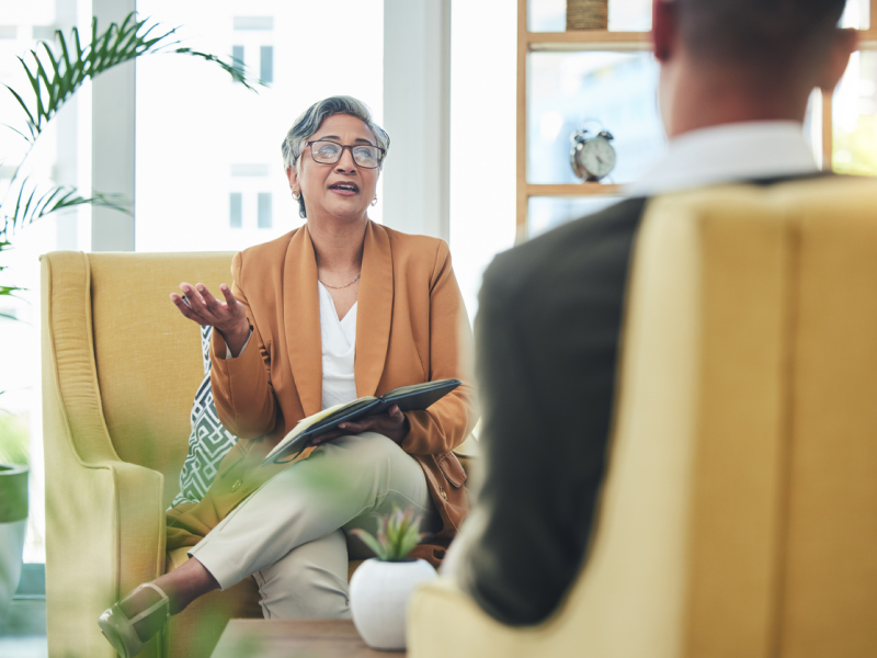 A psychiatrist sits in her office with a client.