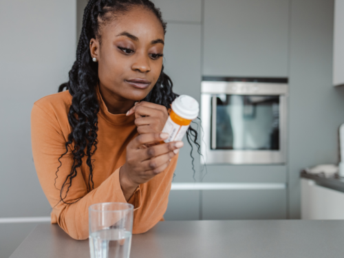 A woman in an orange shirt wonders if she can drink while on antidepressants.
