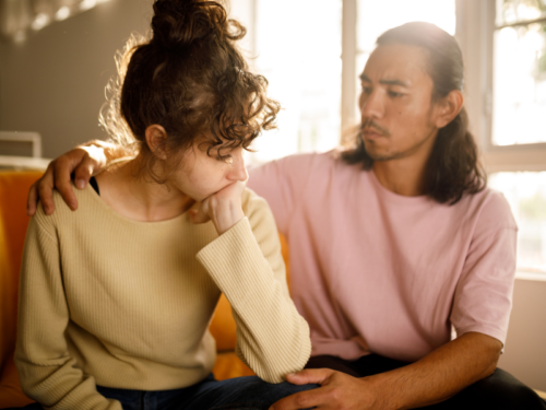 A man comforts his partner who is experiencing alcohol-induced psychosis.