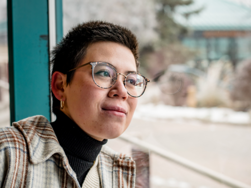 A person who experiences gender dysphoria looks out of a window.