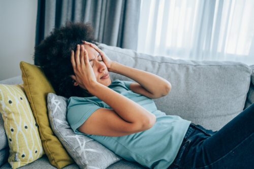 Woman sitting on the couch feeling panicked.
