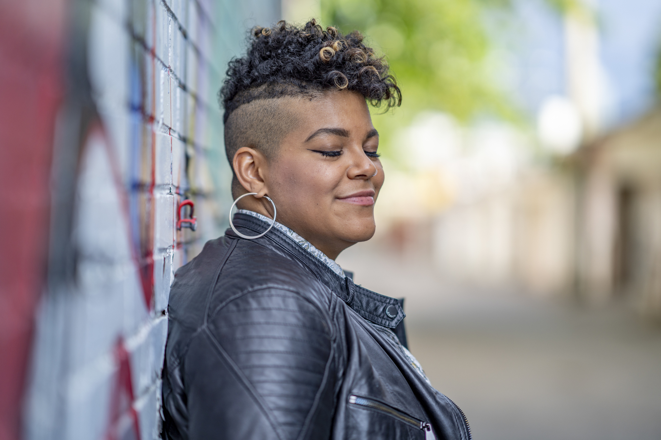 A young woman poses for a portrait while enjoying the outdoors and feeling content